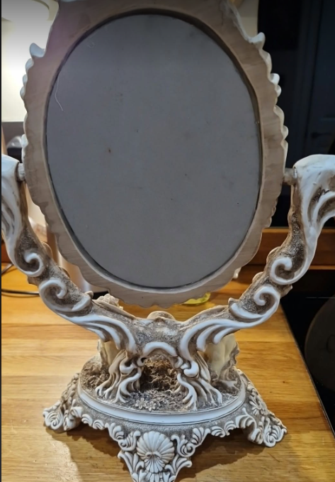 Actual rear view of vintage ornate cherub vanity mirror