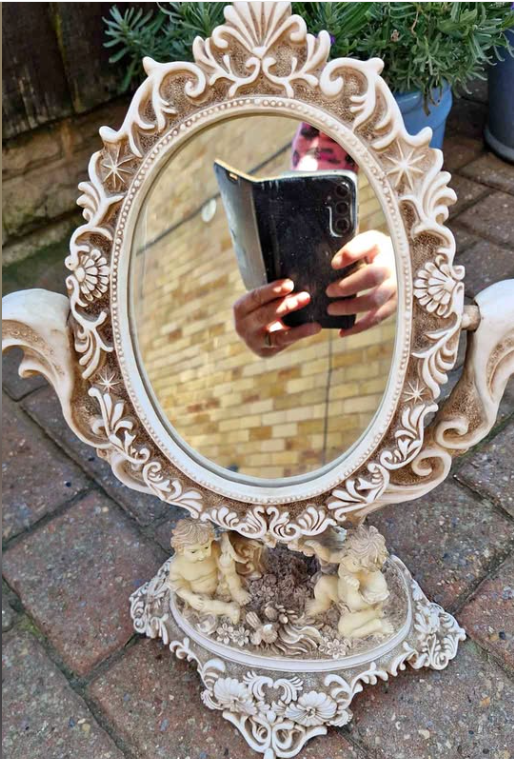 Actual front view of vintage ornate cherub vanity mirror